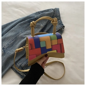 Détail macro du mini sac patchwork géométrique avec base incurvée et chaîne dorée