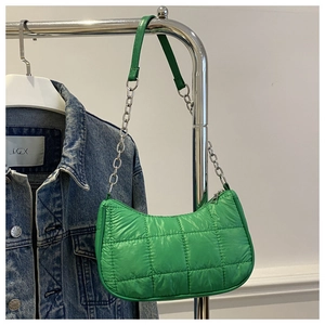 Detailed view of quilted green nylon shoulder bag with silver chain strap texture