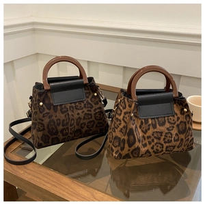 Detail view of leopard print faux fur tote bags with round handles and metal studs