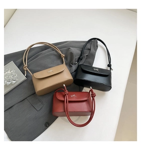 Detail of elegant crossbody bags with metallic bow accent and knotted rope straps