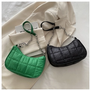 Détail des sacs hobo matelassés verts et noirs avec des bandoulières en chaîne argentée
