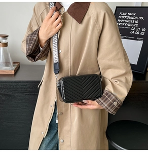 Détail du sac bandoulière noir matelassé en V avec large sangle tissée tendance