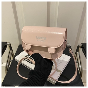 Détail du sac selle rose clair avec lettrage argenté et bandoulière réglable