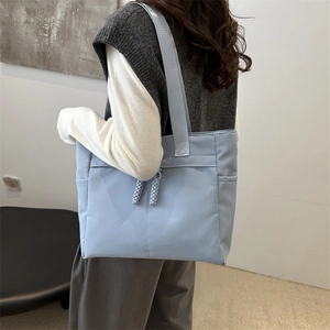 Light blue nylon tote bag for women with woven zip pendants and wide shoulder straps
