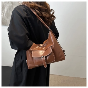 Brown vintage tote bag detail with front flap pocket and contrast stitching on the model