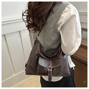 Detail of chocolate brown hobo bag featuring white contrast stitching and a small front pocket