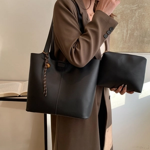 Minimalist black tote bag set with matching pouch and woven knot detail for daily commute