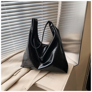 Detail of glossy black leather tote bag showing high-shine finish and spacious Hobo design
