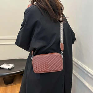 Sac à bandoulière matelassé marron avec motif en V et large sangle géométrique