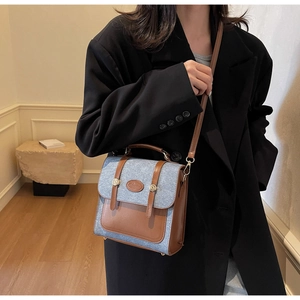 Detail of a retro patchwork crossbody bag with brown leather trim and blue denim texture