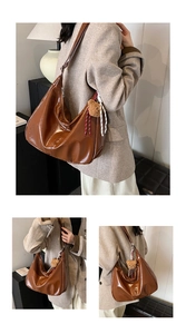 Close-up of brown glossy leather hobo bag with a cute bear plush pendant and zipper detail