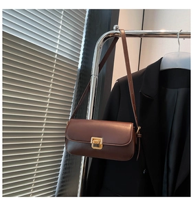 Detail einer braunen Lederhandtasche im Vintage-Stil mit goldenem Drehverschluss