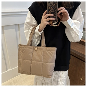 Quilted tote bag detail showing khaki padded fabric and large diamond stitched pattern