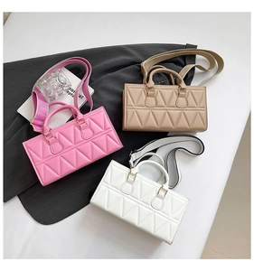 Detail of three quilted triangular handbags in pink, beige, and white with wide straps