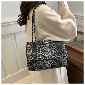 Macro shot of stylish leopard print texture and metal chain strap on crossbody bag