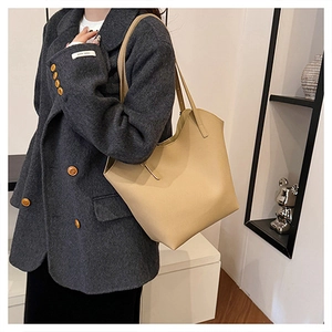 Elegante borsa tote beige in pelle da donna mostrata con comodo trasporto a spalla laterale