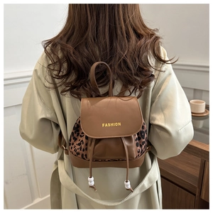 Mini sac à dos en cuir marron avec détails léopard porté par un mannequin de dos
