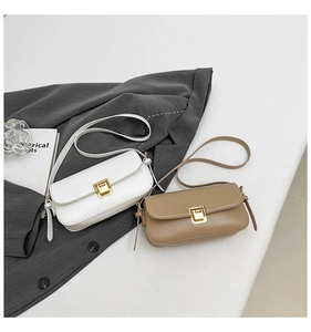 Detail minimalistischer Schultertaschen in Weiß und Khaki mit goldenen Metallverschlüssen