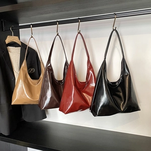 Large shiny hobo tote bags in four vintage colors hanging on a minimalist rack
