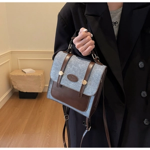 Detail of vintage patchwork mini backpack in denim blue and brown leather with metal buckle