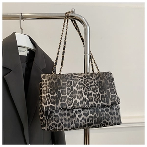 Chic leopard print crossbody bag with gold chain strap on a blazer background