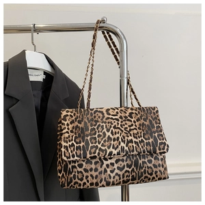Detail of trendy leopard print shoulder bag with elegant gold chain strap and flap cover