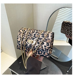 Détail d'un sac à bandoulière léopard avec chaîne dorée et fermoir pivotant carré