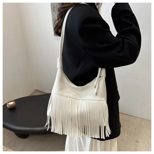 Detalle del bolso de hombro en cuero blanco con grano y flecos largos de estilo moderno