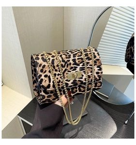 Détail du sac à main léopard avec bandoulière chaîne dorée et fermoir rotatif métallique