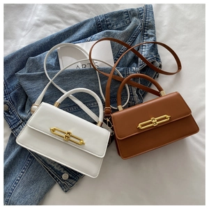 Detail view of mini crossbody bags in white and brown with gold chain lock hardware