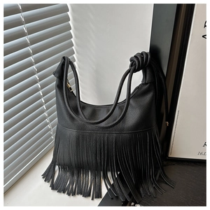 Detalle del bolso de hombro creciente negro con flecos y correa con nudo