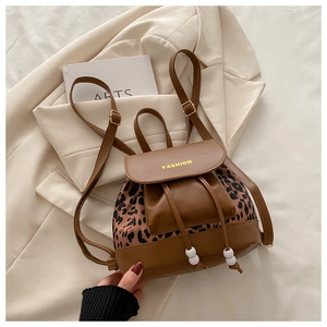 Détail du panneau léopard sur sac à dos en simili cuir avec logo et rabat magnétique