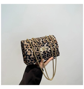 Détail du sac léopard avec chaîne dorée et fermoir rotatif en gros plan sur la texture