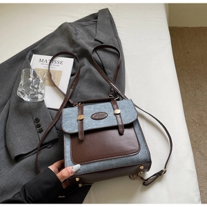 Detail of retro blue-grey fabric and brown PU leather patchwork backpack with gold studs