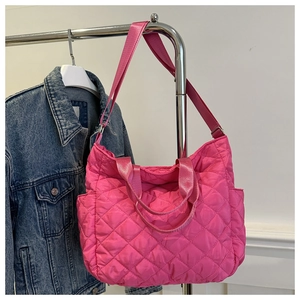 Detail of rose pink quilted tote bag with diamond stitching and side storage pocket