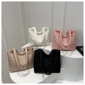 Détail de sacs cabas matelassés en forme de cœur en noir, beige, rose et blanc doux