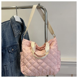 Detailed view of pink quilted tote bag with side pockets and cream strap handles