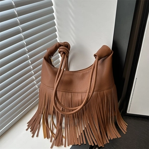Vintage brown leather tote bag with long fringe tassels and decorative knotted shoulder strap