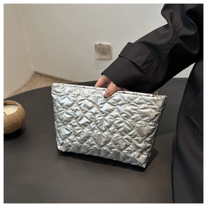 Gros plan sur le matelassage en forme de cœur argenté sur la trousse à maquillage
