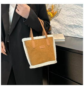 Detail of camel faux suede bucket bag featuring white faux shearling trim and fashion label