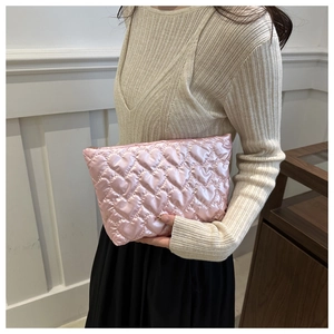 Detail of pink satin heart quilted puffer bag showing glossy texture and elegant design