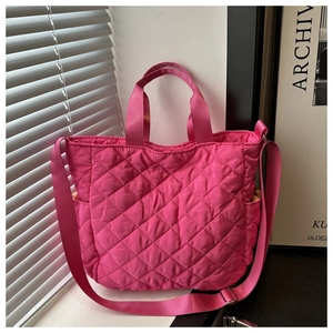 Detail of rose pink quilted tote bag with adjustable strap and side pockets macro view