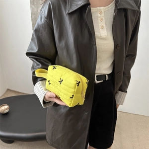 Bright yellow quilted nylon handbag with black bow patterns and gold zipper closure
