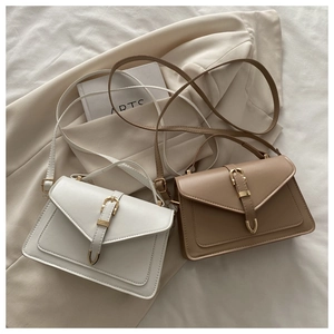 Détail de petits sacs carrés élégants blanc et kaki avec rabat en V et boucle dorée