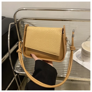 Detail of solid color crossbody bag with smooth leather and woven texture stitching