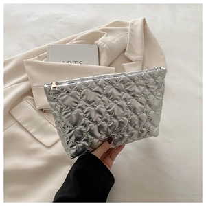 Close-up of metallic silver quilted heart makeup bag with golden zipper and waterproof fabric