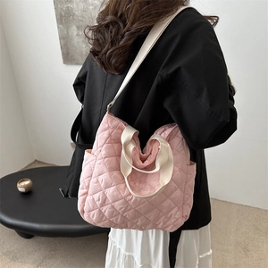 Pink quilted nylon tote bag with rhombus stitching and adjustable straps on model