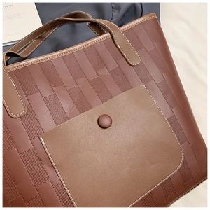 Detailed view of woven vintage tote bag with leather straps and contrast stitching