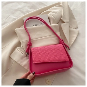 Detail of rose pink crossbody bag showing woven texture flap and smooth finish