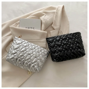 Detailed view of silver and black quilted heart pouches with glossy finish and zipper
